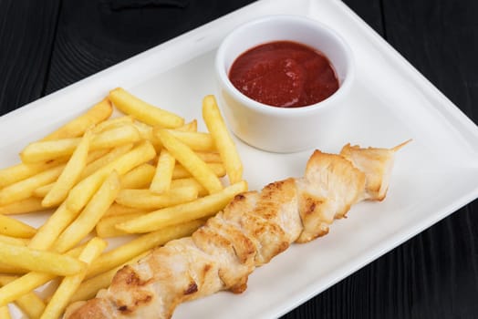 Grilled chicken meat with fried potatoes on white plate