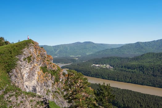 Man standing on top of cliff in summer beauty day in Altai mountains
