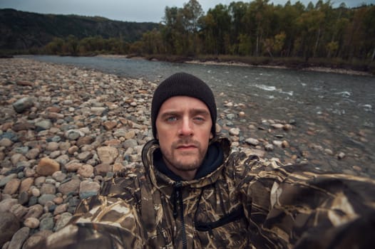 Caucasian man in the mountain making selfie on background nature landscape