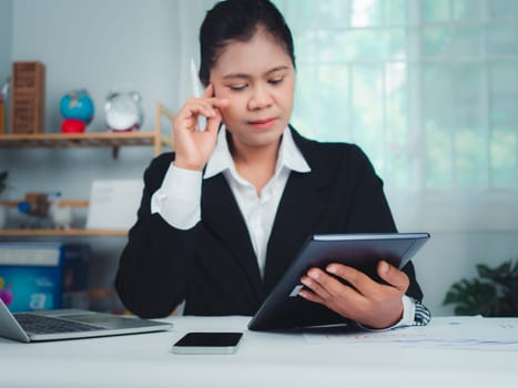 Businesswoman working with stress because she is very tired working with laptop and documents on the table, Woman sleepy and bored from work, Sitting at a desk at the office and looking at laptop.
