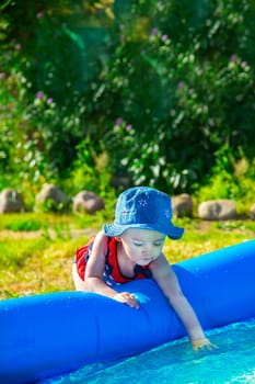 On a beautiful sunny day, a joyful child plays by the pool, completely giving himself up to summer fun