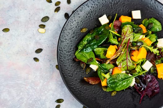 Plate of roasted pumpkin with salad. Roasted butternut squash salad. Healthy diet concept.