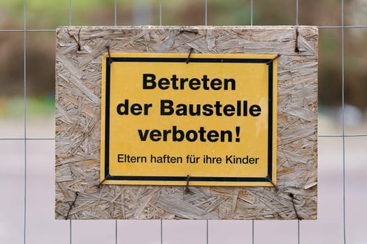 Sign on a fence with the german inscription Betreten der Baustelle verboten. Translation: No trespassing on the construction site