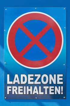No stopping sign with the German inscription Ladezone freihalten. Translation: Keep loading zone free