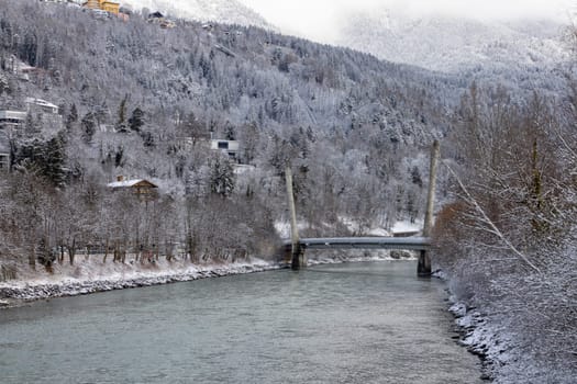 Bridge of Hungerburg Innsbruck Funicular over river Inn, Snow covered slope of Alps in the clouds in dinstance, Innsbruck, Austria