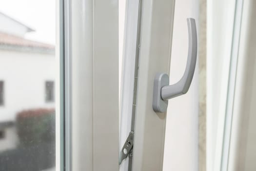 Window tilt open in a city apartment, letting in fresh air. Energy efficiency.