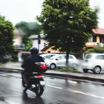 Man in the rain with his motorcycle. Man riding motorcycle in the rain on road.