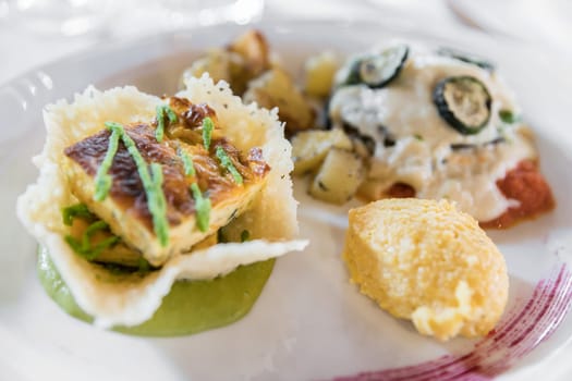 Vegetarian plate with polenta, potatoes and focaccia. Italian gourmet decoration.