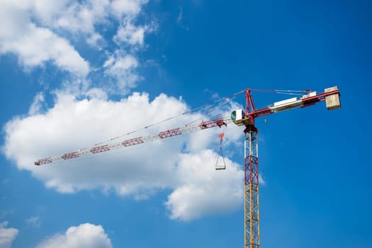 Detail of construction tower crane against blue sky