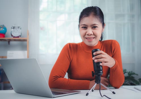 Content creator concept, woman talking into microphone on stand, lead on-line communication, discuss topic, looks at notebook screen, Engaged in streaming, Virtual meeting event, Podcast, Webinar.