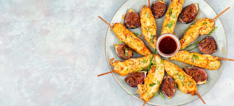 Grill skewers with grilled chicken and figs on a plate. Healthy food concept. Barbecue, chicken kebab. Flat lay.