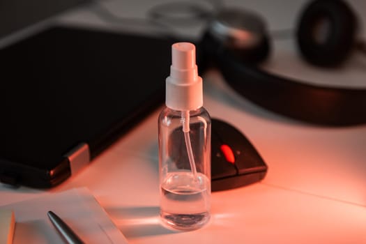 Sanitizer anti virus spray on the working table with laptop. Personal hygiene concept. Concept of quarantine for coronavirus and working from home.