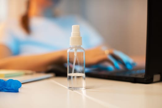 Coronavirus concept. Woman in quarantine for coronavirus covid-19 working from home. Protective mask and Sanitizer spray on the working place