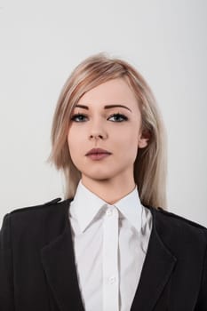 Confident young businesswoman in a stylish suit and white shirt exudes professionalism and determination with her stunning blue eyes, reflecting ambition and leadership in the corporate world
