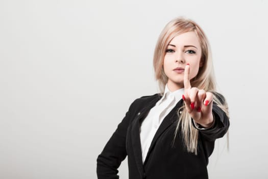 Confident businesswoman in white background, making stop gesture, exuding power and success. Elegant appearance, red nail polish, serious demeanor