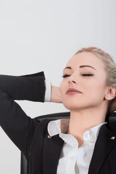 Businesswoman taking a break from work, relaxing with eyes closed and hands behind her head, exuding calm and peace. Reflecting on work life balance and mindfulness for wellbeing
