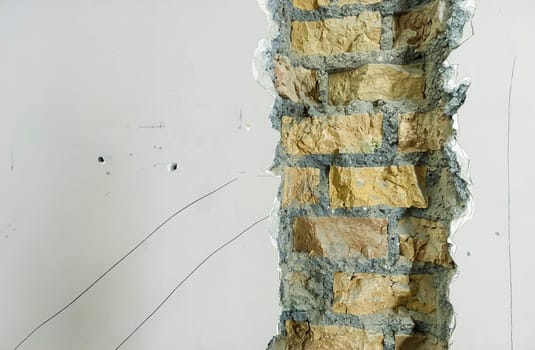 Close-up of an exposed brick wall section during renovation, showing raw masonry and construction details, highlighting an ongoing interior project