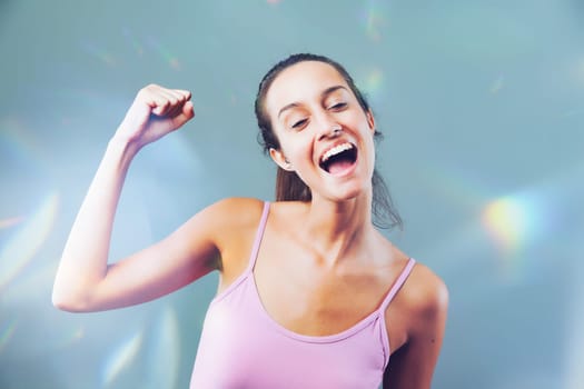 Young woman celebrates success with a radiant smile and triumphant gesture, reflecting joy and accomplishment
