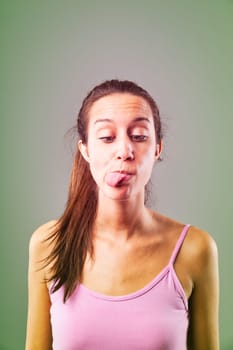 Young woman is sticking out her tongue, conveying a range of emotions and thoughts, creating a playful and expressive portrait
