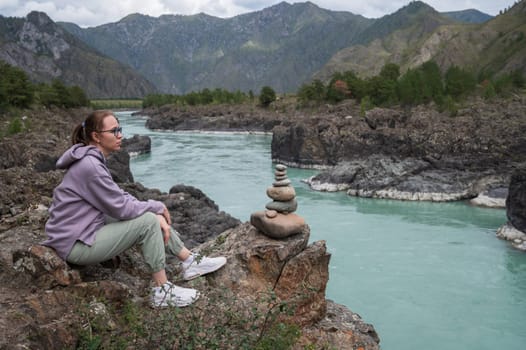 Woman at the river Katun at summer day. Trip on Altai Mountains in Altai Republic