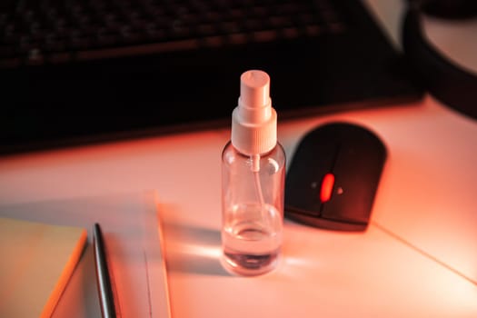 Sanitizer anti virus spray on the working table with laptop. Personal hygiene concept. Concept of quarantine for coronavirus and working from home.
