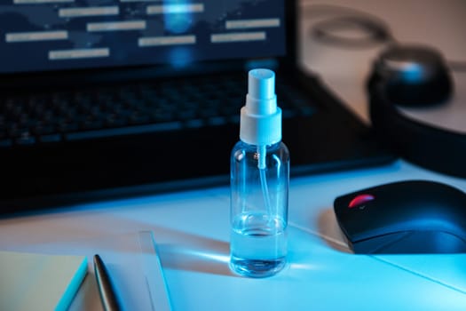 Sanitizer anti virus spray on the working table with laptop. Personal hygiene concept. Concept of quarantine for coronavirus and working from home.