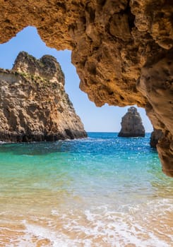 Small, heavenly and difficult to access beach vertically photographed from inside the rocks, near Portimão in the Algarve region of Portugal