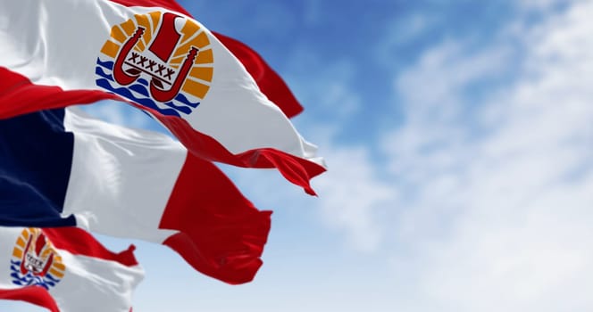 Flags of French Polynesia and France waving in the wind on a clear day. French Polynesia is an overseas collectivity of France and its sole overseas country. 3d illustration render. Selective focus