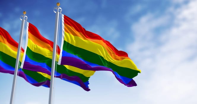 Rainbow flag waving on a clear day. Multicolored flag with stripes in the colors of the rainbow, often used as a symbol of LGBT pride. 3d illustration render. Fluttering fabric