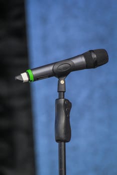 A microphone stands on a stage, unused during a break.