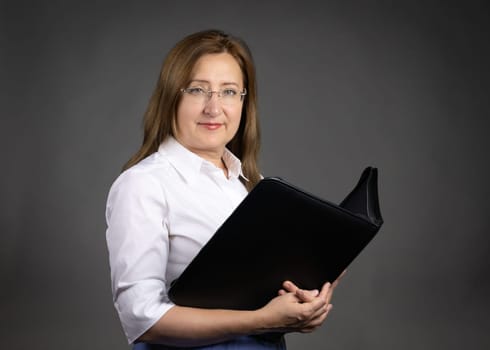Portrait of a mature professional woman holding a document binder