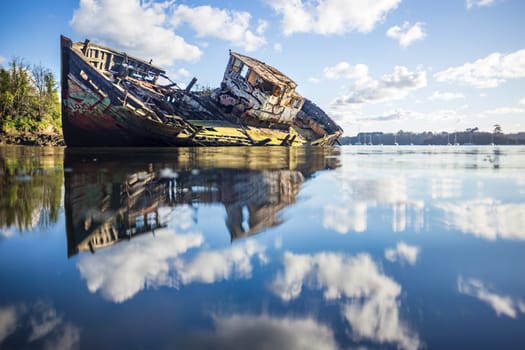 Wooden wreck boat sinking in the clouds
