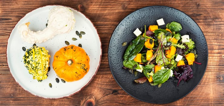 Plate of roasted pumpkin with salad. Roasted butternut squash salad. Healthy diet concept. Flat lay with copy space.