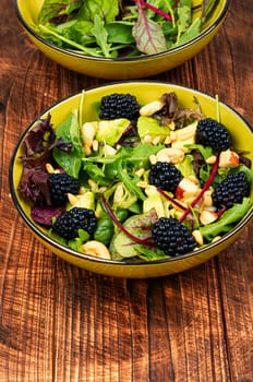 Green vitamin salad with blackberries, microgreens, avocado and pine nuts. Rustic style.