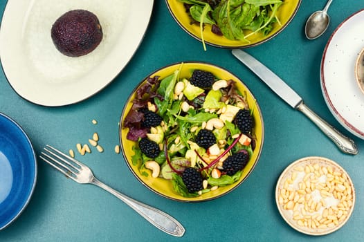 Green vitamin salad with blackberries, microgreens, avocado and pine nuts. Rustic style.