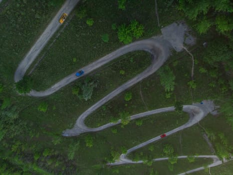 Aerial top vew of winding road in the city, with cars , drone shot
