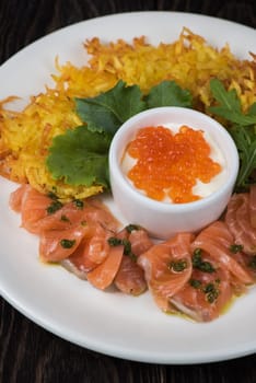 Plate with potato pancakes salmon fish and red caviar
