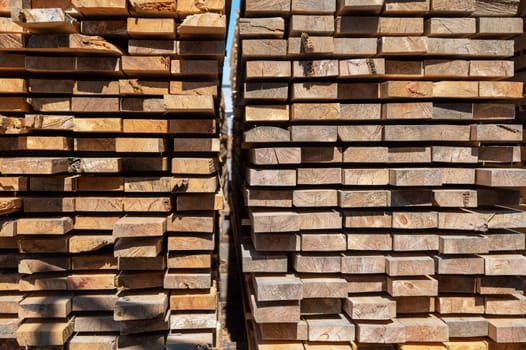 Stacked wooden planks close-up at lumber warehouse. Wood industry concept