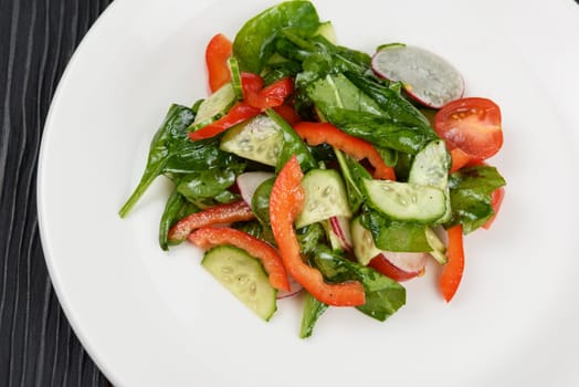 Vegetable vegetarian salad on white plate, closeup