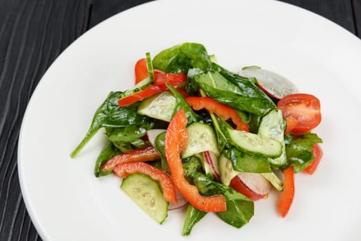 Vegetable vegetarian salad on white plate, closeup