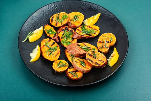 Roasted sweet potatoes slices on the grill. Vegan food.
