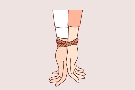 Tied hands of people in toxic relationships symbolize communication problems among men and women in love. Toxic relationships in unhappy couple forced to feel mutually dependent on partner