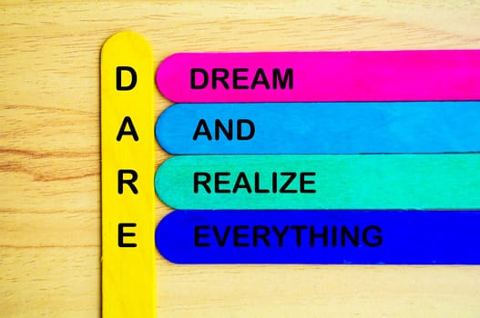 Dare represent Dream And Realize Everything text on multicolored sticks. Daring concept.