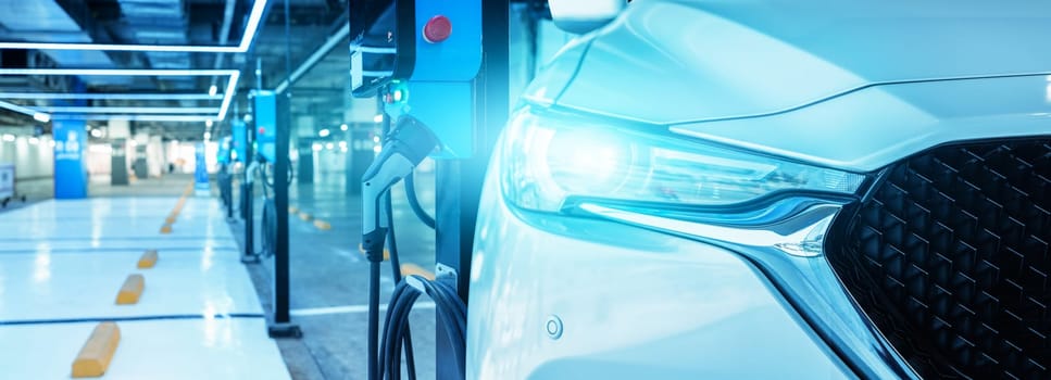 Electric vehicle charging station in indoor mall parking, EV battery charging point for sustainable transport, clean energy infrastructure for electric car, commercial charging facility in parking lot