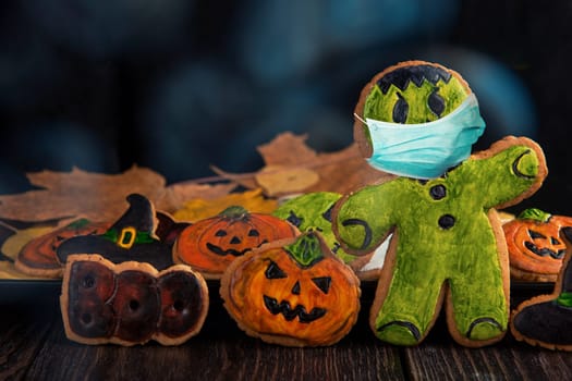 Ginger biscuits with face mask for Halloween holiday on wooden, concept of covid hallowen
