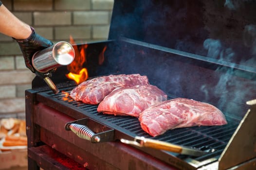 Pork meat steaks on the grill with flames