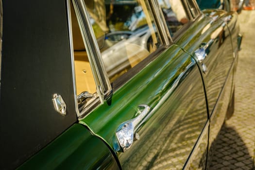 Lisbon, Portugal - Jan 20, 2024: Details of side view of classic green Rover P6 Series II or Mark II 2000 TC executive car, 4 door saloon, parked on a cobblestone path in a city. Doors, handles, emblem and open quarter window in selective focus