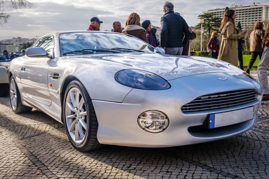 Lisbon, Portugal - Jan 20, 2024: Luxury Aston Martin DB7 Vantage 2002 roadster parked on a cobblestone road, blue body, unique sports car.