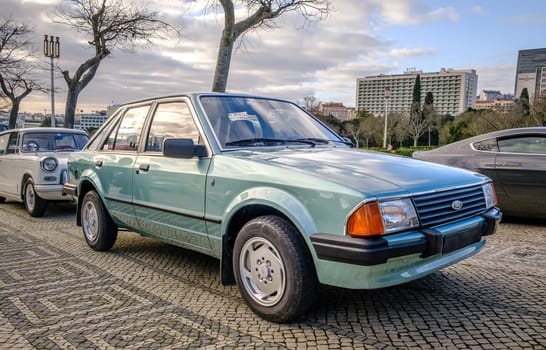 Lisbon, Portugal - Jan 20, 2024: A classic light green Ford Escort 3rd generation car known as Erika, 5 door hatchback, parked on a cobblestone road in a city.