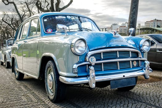 Lisbon, Portugal - Jan 20, 2024: A classic two-tone Morris Oxford Series III car parked on a cobblestone path on cloudy day, family car, two color coating, British Motor corporation